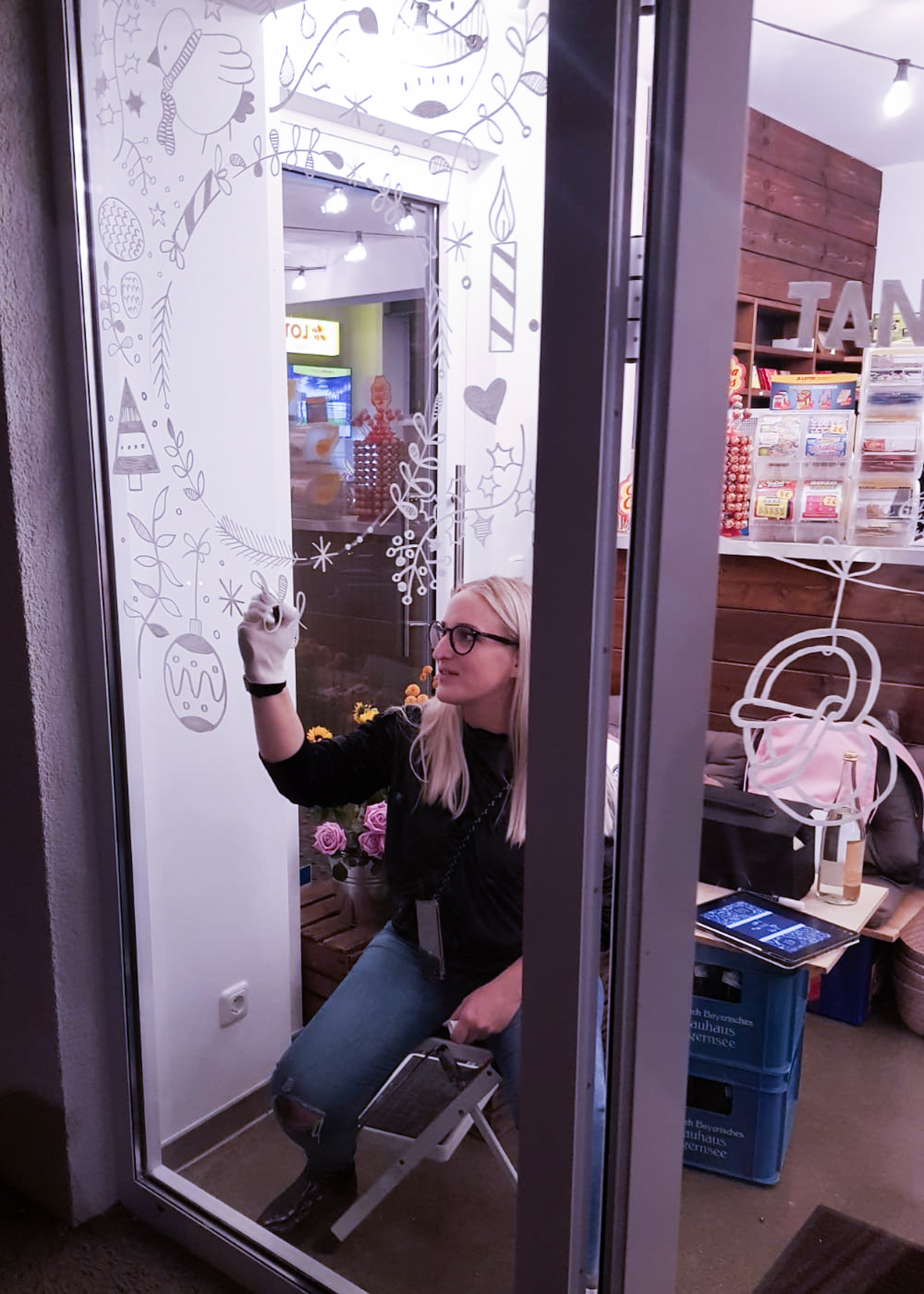 Lena malt das Schaufenster der Superkiosks Tante Ohm mit Markerstiften an.