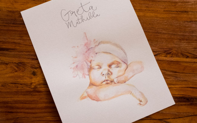 Ein Babyporträt mi Aquarelltechnik gemalt und dem Namen in Handschrift.
