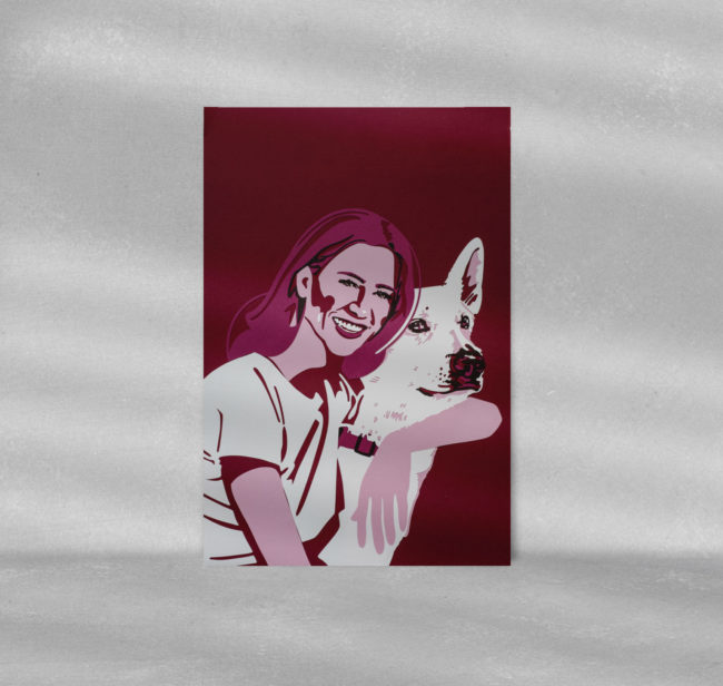 Ein Papercut Porträt einer Frau mit Hund in einem Bilderrahmen.